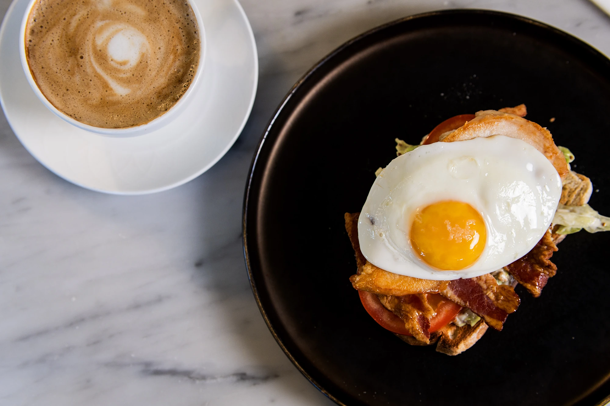 Breakfast toast with egg, bacon, and latte.